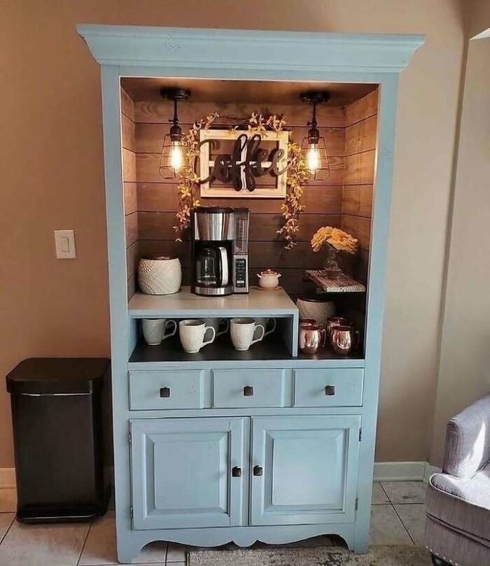 Recycled cabinet transformed into a coffee station with lights and decor.