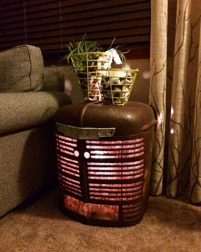 Vintage tractor grill repurposed as a lamp, showcasing creative recycling in a cozy room corner.