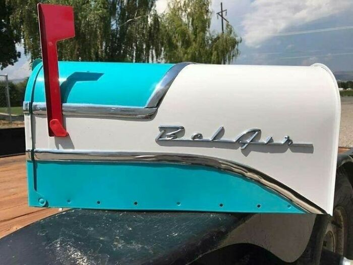 Vintage car-themed mailbox, creatively recycled with bright colors and chrome detailing, sitting outdoors.