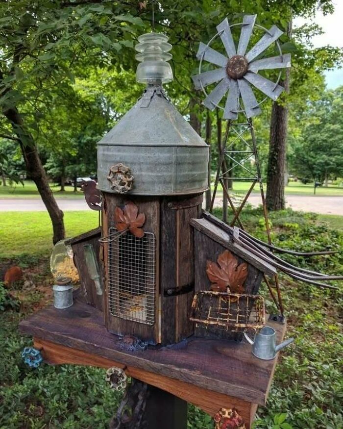 Recycled materials create a unique birdhouse with rustic design, featuring metal accents and creative reuse elements.