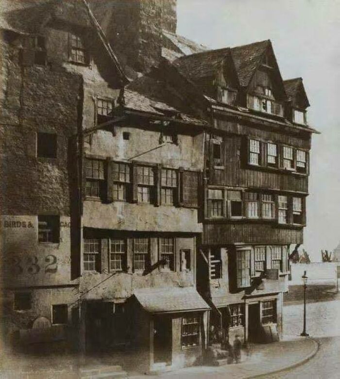 Historic building facade showing old architecture with multiple windows and wooden structures.