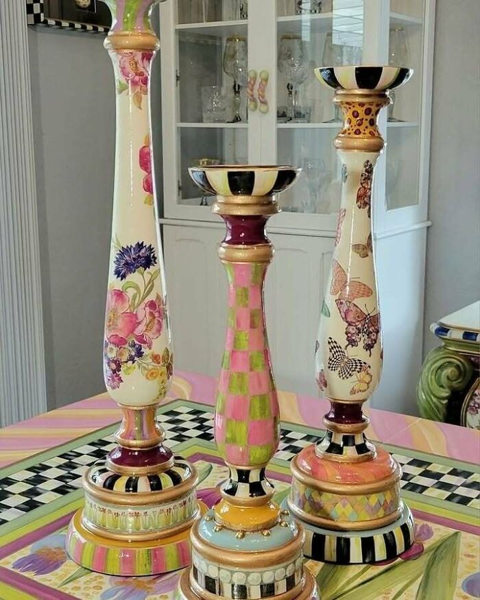 Colorful recycled candle holders with floral and checkered patterns on a decorated table.
