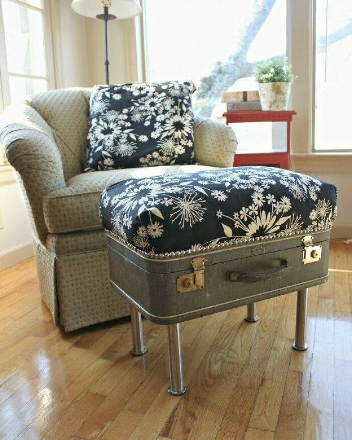 Vintage suitcase repurposed as a stylish footstool, showcasing creative recycling in home decor.