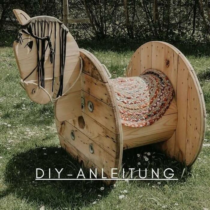 Recycled wooden horse sculpture in a garden, showcasing creative recycling ideas.