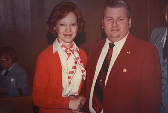 A man and woman in red outfits posing together, linked to photographs with terrifying backstories.