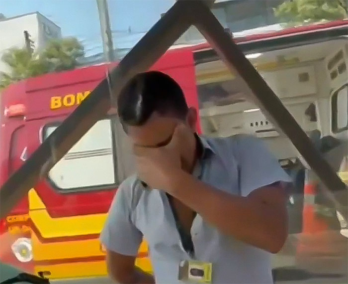 Man covering face near emergency vehicle after aviation disaster.