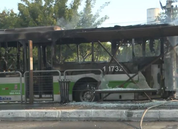 Burnt bus on the street following an aviation disaster, with visible damage and smoke.