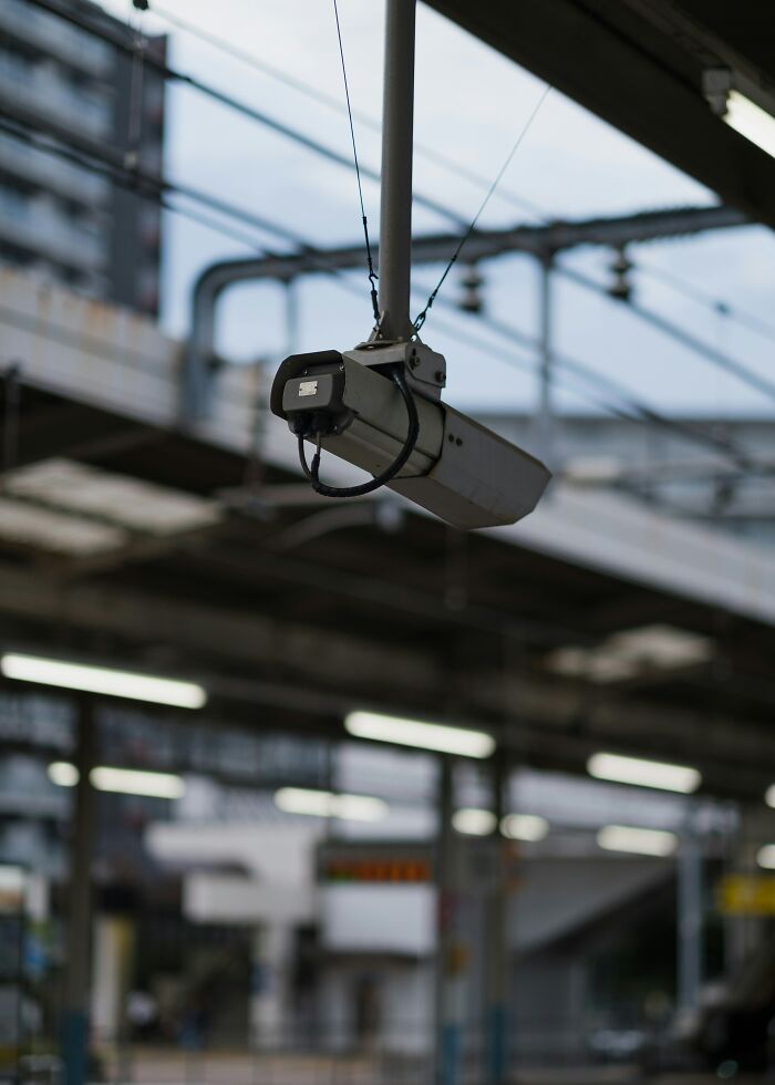 Security camera hanging from the ceiling in an industrial setting, capturing movie moments inaccurately.