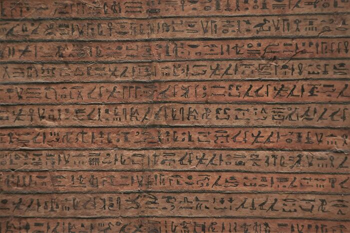 Ancient hieroglyphics etched on a stone surface, showcasing historical writing techniques.