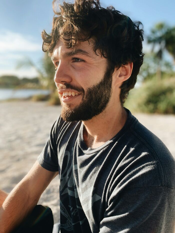 Man smiling outdoors, wearing a gray shirt, symbolizing relatable moments in movies.
