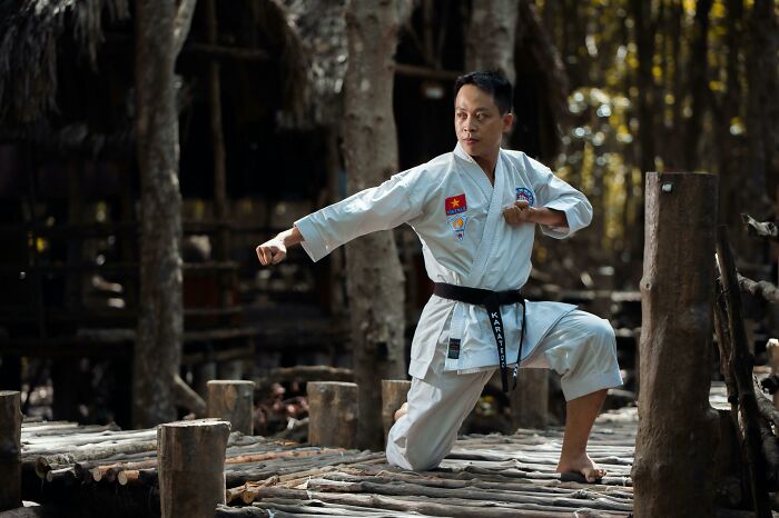 Martial artist in action pose on a wooden platform, illustrating a movie moment that makes people question accuracy.