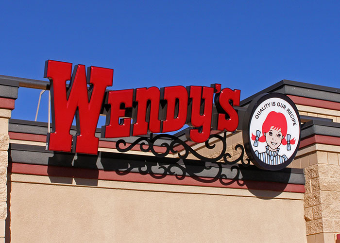 Wendy's sign on a building under a clear blue sky, showcasing a product that failed despite being good.