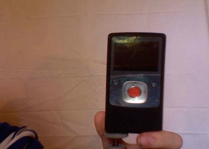 Hand holding a Flip Video camera, a product that failed despite being good.