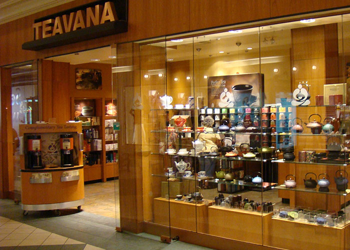 Teavana storefront displaying various tea products in a brightly lit shop setting.
