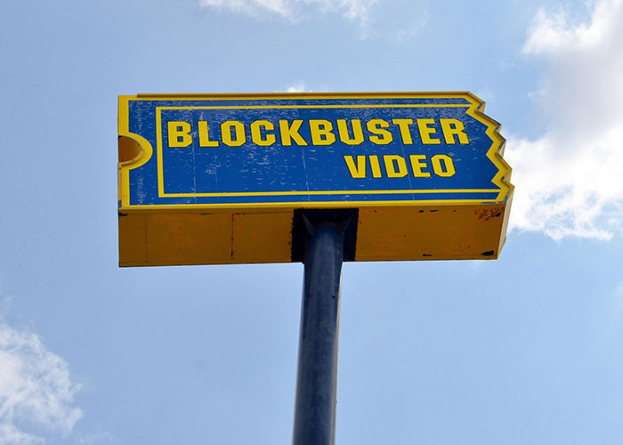 Blockbuster Video sign against a blue sky, representing failed products that were once popular.