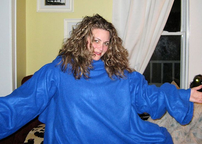 Person wearing a blue snuggie, smiling indoors, highlighting product that failed despite being good.
