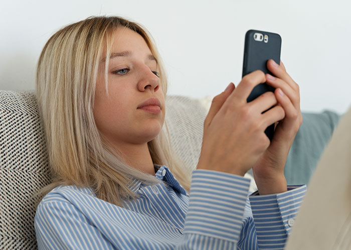 Person in blue striped shirt using a smartphone, representing failed products despite being good.