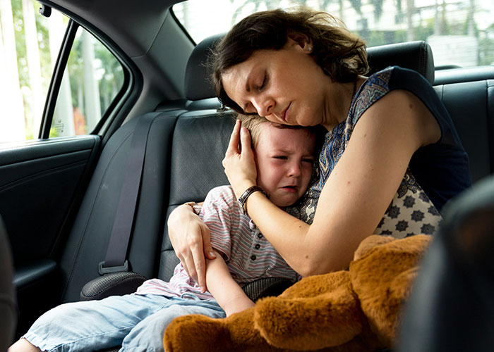 Mom comforting upset son in car, dealing with stepsiblings and family dynamics, highlighting themes of being unfair and strict.