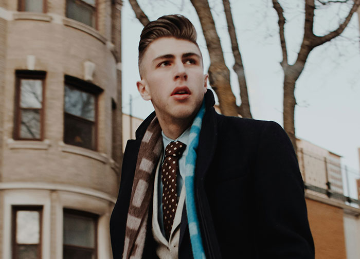 Person wearing a suit and scarf outdoors, possibly contemplating quitting a job on the spot.