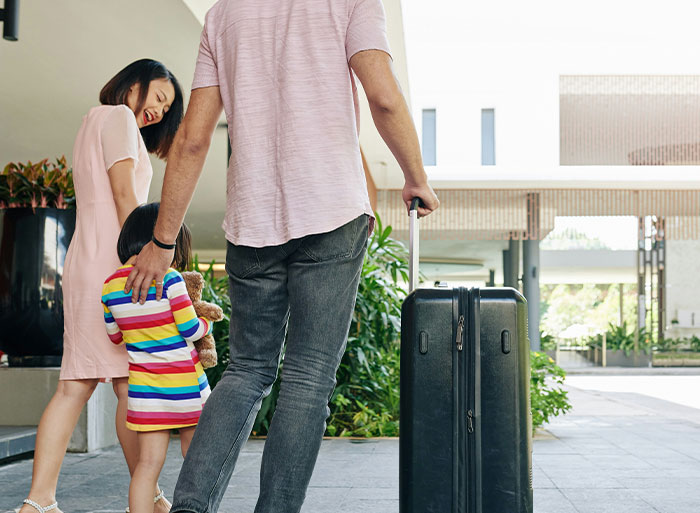 Family leaving a building with luggage, symbolizing quitting a job on the spot for new beginnings.