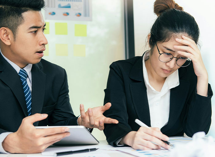 Two colleagues in an office setting discussing as one appears stressed, related to quitting a job.