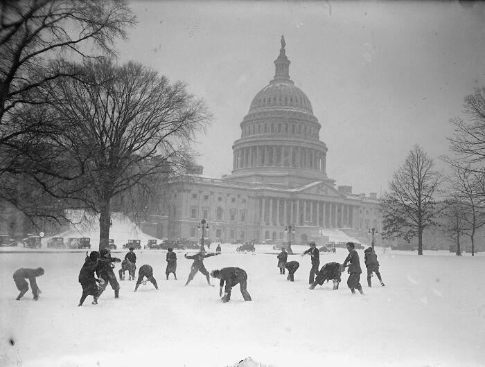 Historic photo of people playing in the snow near the U.S. Capitol, showcasing rare moments from the past.