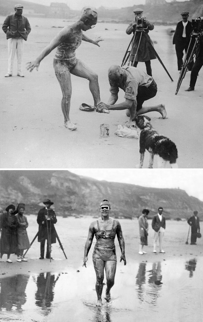 People covered in mud on the beach, rare historical photo capturing an unusual scene with onlookers and photographers.