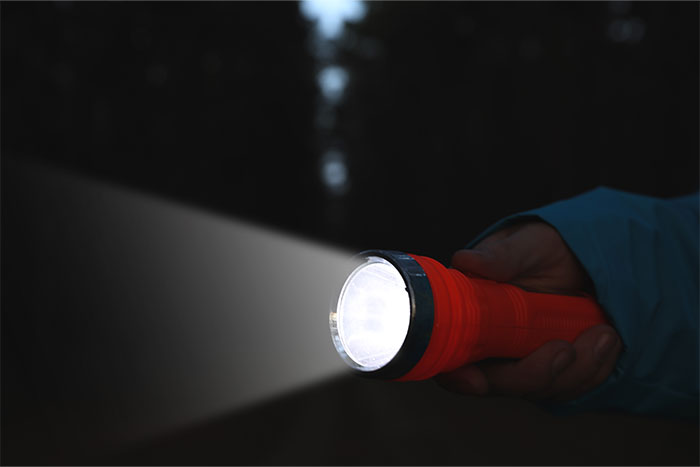 Hand holding a flashlight in the dark, demonstrating the wrong use of technology for years.