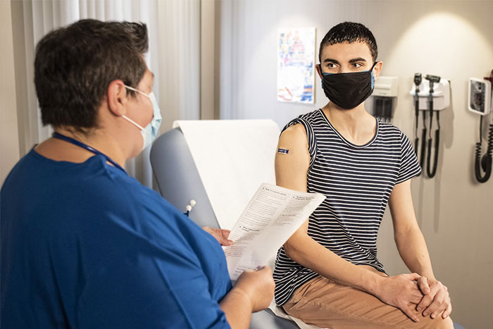 Patient discussing health concerns with a masked nurse, highlighting mistakes done for years.