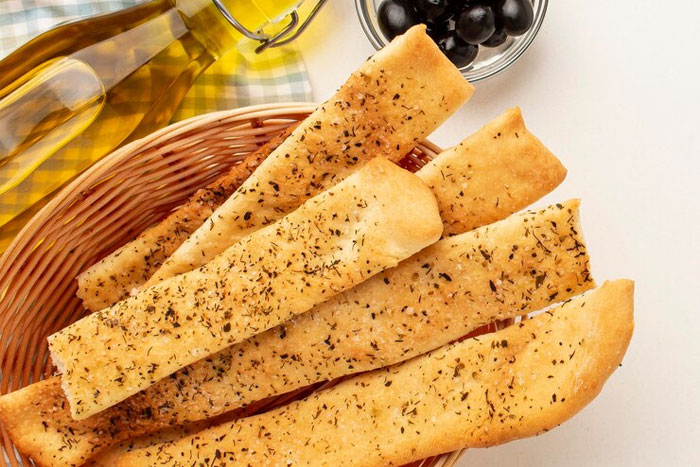 Basket of seasoned breadsticks with olives and olive oil, illustrating moments of doing something the wrong way.