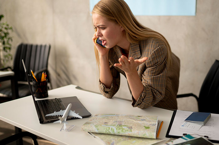A frustrated woman at work, talking on a phone, symbolizing quitting a job on the first day.