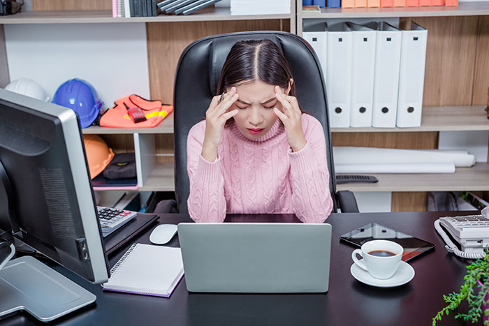 Woman in an office, stressed on first day, considering quitting job after facing unexpected pressures.