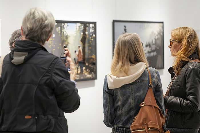 People viewing art in a gallery, engaging in discussion, a metaphor for quitting jobs first day due to a decisive moment.