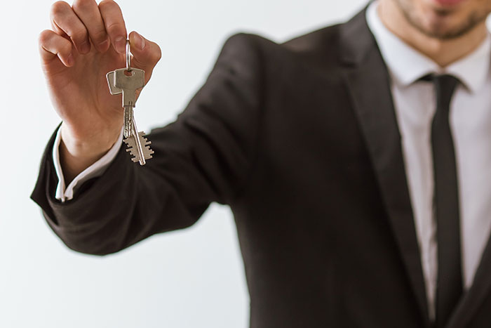 Man in suit holding a key, symbolizing quitting jobs on the first day over dissatisfaction.