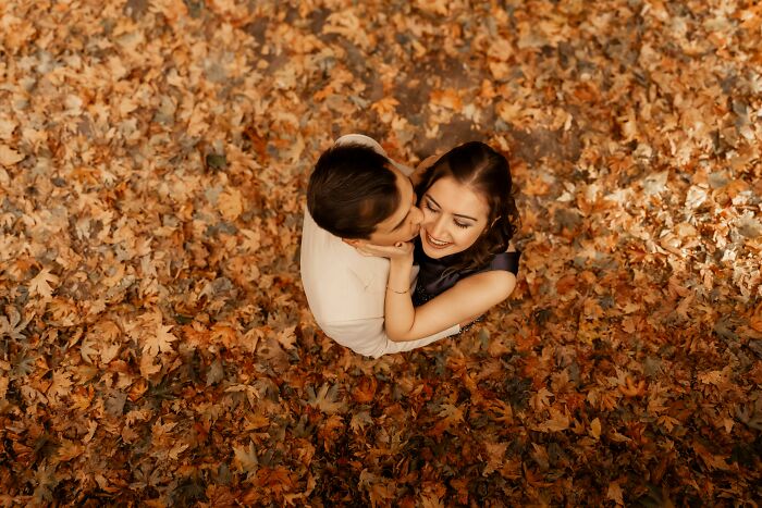 Couple embracing on autumn leaves, symbolizing marriage and spouse connection.