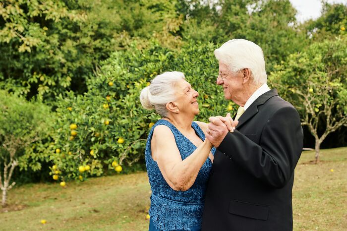 Elderly couple dancing in a garden, exemplifying a content marriage without regret of their spouse.
