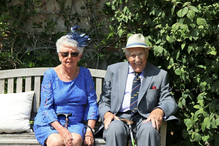 Elderly couple sitting on a bench, celebrating decades of respect in their relationship.