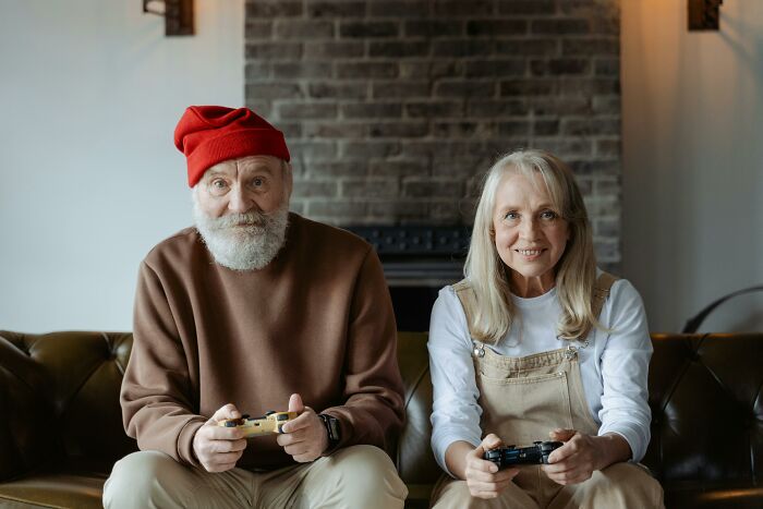 Elderly couple playing video games, illustrating respect and a strong relationship over decades.