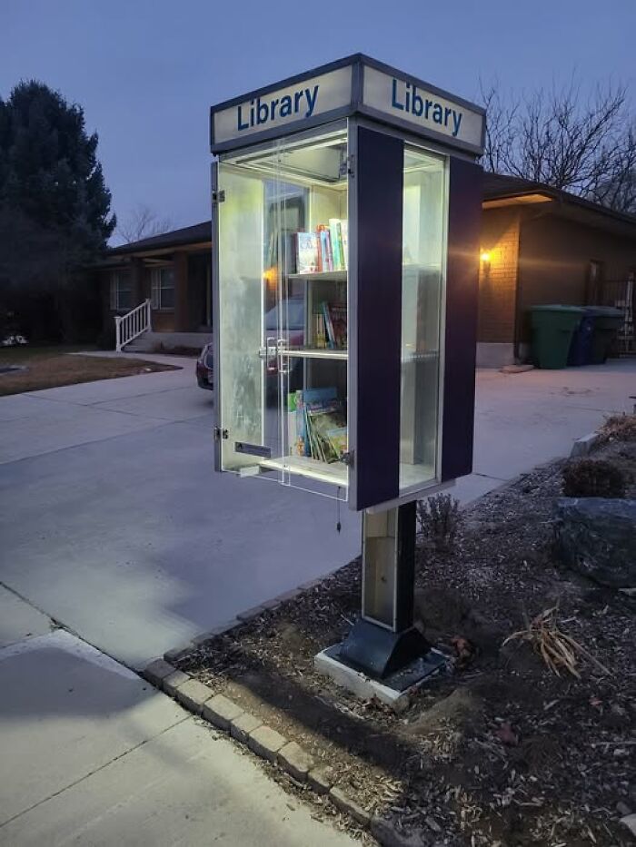 Repurposed phone booth turned into a mini library, showcasing an inspiring recycling idea.