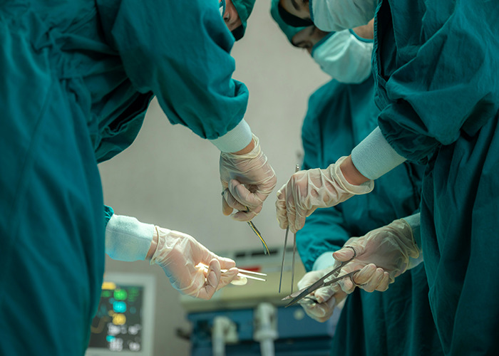 Surgeons in green scrubs performing a procedure, focusing on proactive health measures and readiness for RFK Jr.'s role.