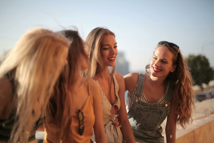 Group of women laughing outdoors, capturing a carefree moment associated with rich people's annoying lifestyles.