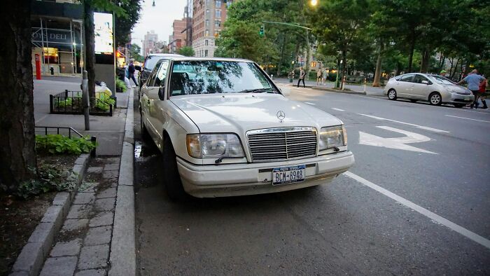 Mercedes parked on a city street, illustrating people's habits in urban settings.