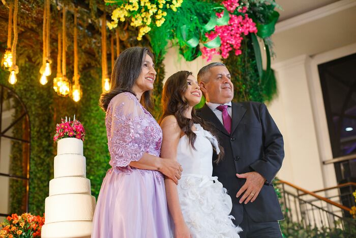 Family posing at an elegant event with a tiered cake and floral decorations, depicting a story of overnight wealth.