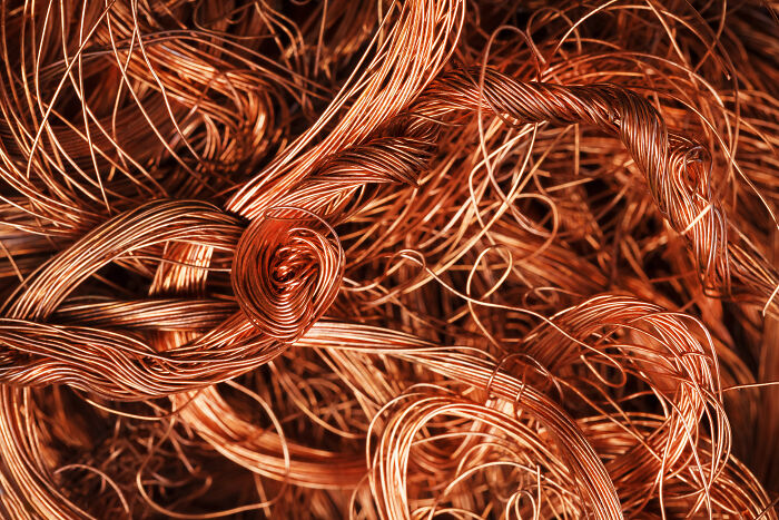 Close-up of tangled copper wires, symbolizing wealth and fortune in the journey from tycoons to billionaires.