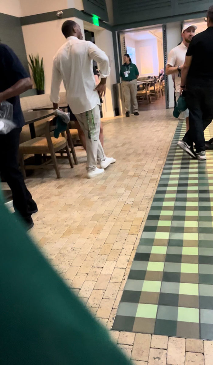 People gathered in a hallway, engaged in conversation, possibly recalling a rude celeb encounter.