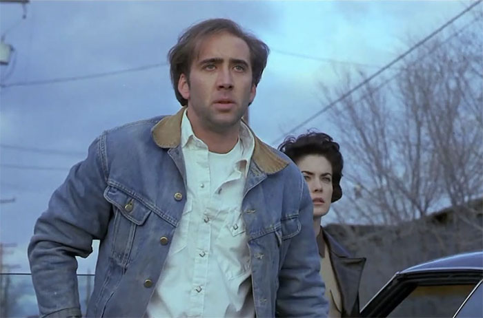 Man in denim jacket and woman standing by a car outdoors, related to rudest celeb encounters.
