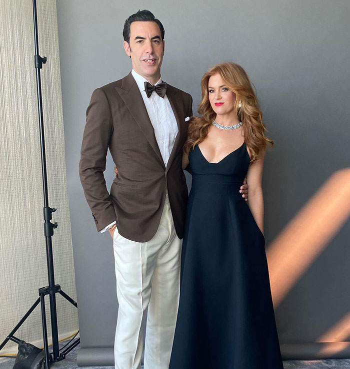 A couple posing elegantly in formal attire against a gray background, connected to Sacha Baron Cohen and divorce news. A couple posing elegantly in formal attire against a gray background, connected to Sacha Baron Cohen and divorce news.