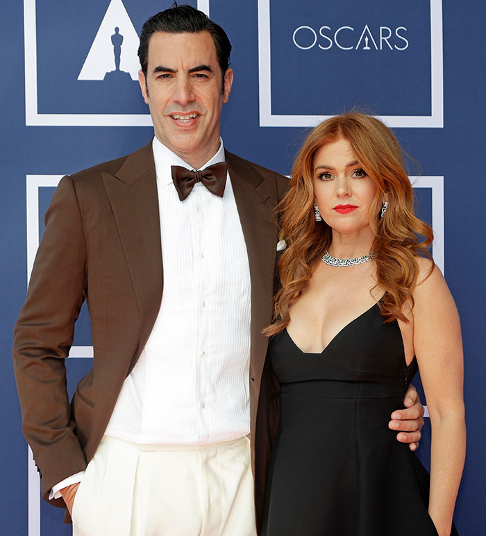 Man in a brown suit with a bow tie and woman in a black dress at an Oscars event, focusing on divorce amid split. Man in a brown suit with a bow tie and woman in a black dress at an Oscars event, focusing on divorce amid split.