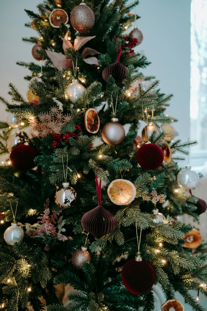 Festive Christmas tree adorned with ornaments and dried orange slices, enhancing holiday ambiance.
