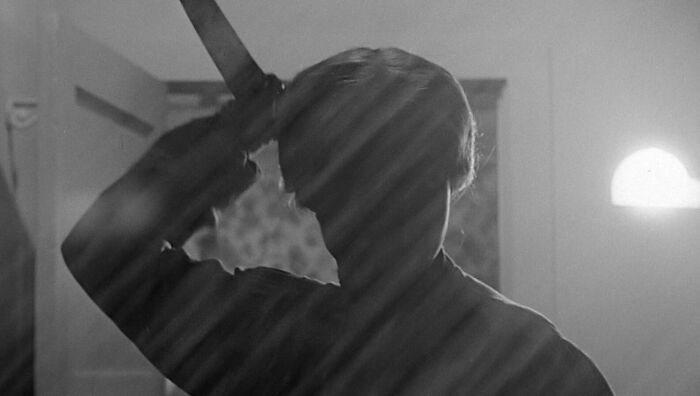 Silhouette of person holding a raised knife, reminiscent of iconic movie prop scenes, with dramatic lighting.